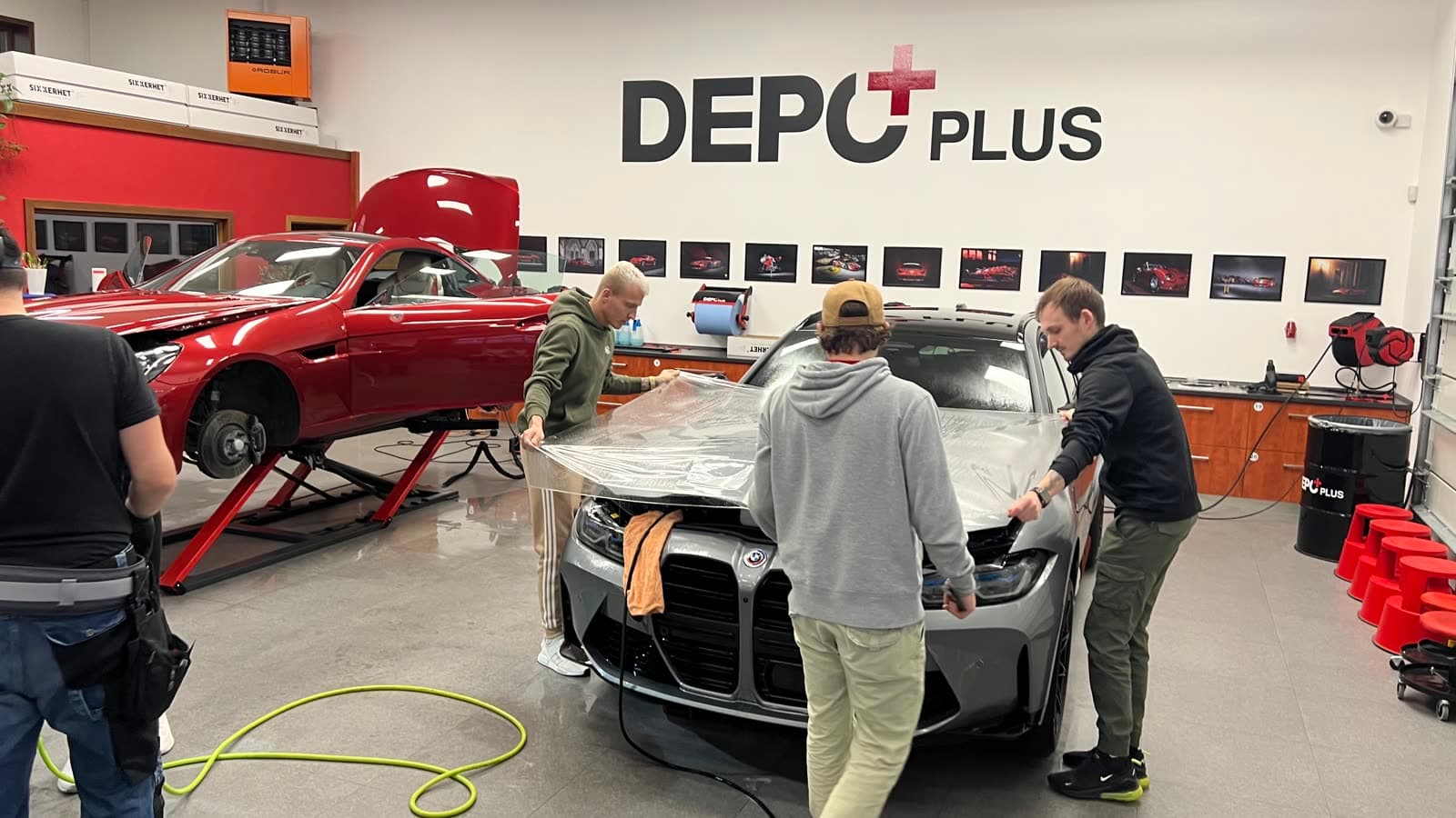 Účastníci kurzu natahují PPF fólii na kapotu BMW M3